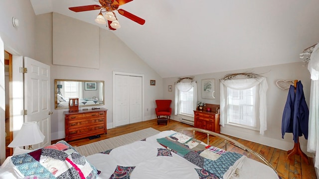 bedroom featuring wood-type flooring, high vaulted ceiling, a baseboard radiator, a closet, and ceiling fan