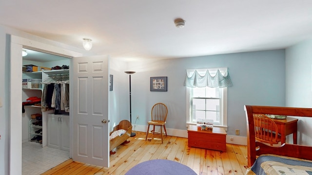 bedroom featuring a closet, a spacious closet, and light hardwood / wood-style flooring