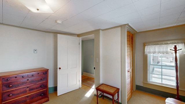 bedroom with ornamental molding and light carpet