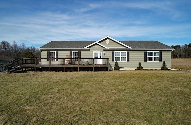 back of property with a wooden deck and a lawn