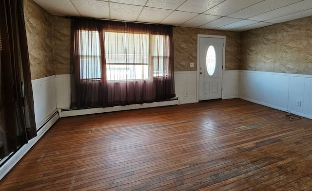 foyer featuring a drop ceiling, dark wood-type flooring, and baseboard heating