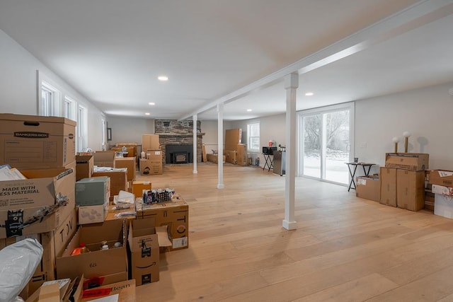 basement featuring a large fireplace and light wood-type flooring