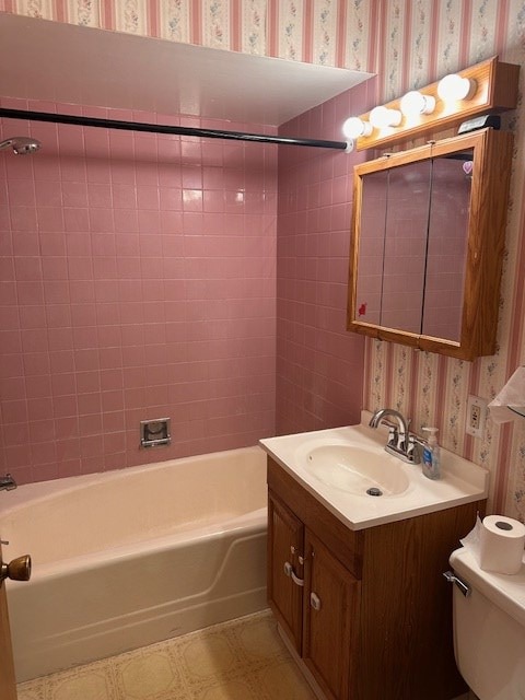 full bathroom featuring tiled shower / bath combo, vanity, and toilet