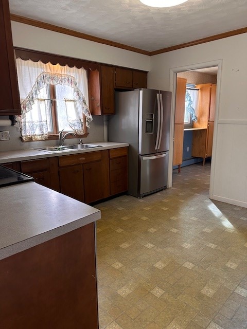 kitchen with crown molding, a healthy amount of sunlight, sink, and stainless steel fridge with ice dispenser