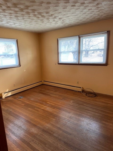 spare room featuring hardwood / wood-style flooring and a textured ceiling