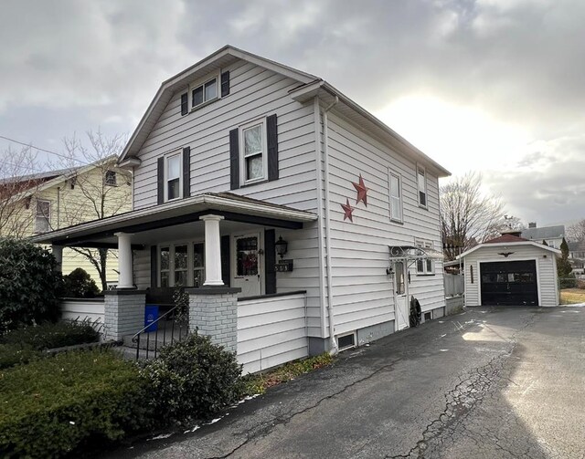 view of front of house with a garage, an outdoor structure, and a porch