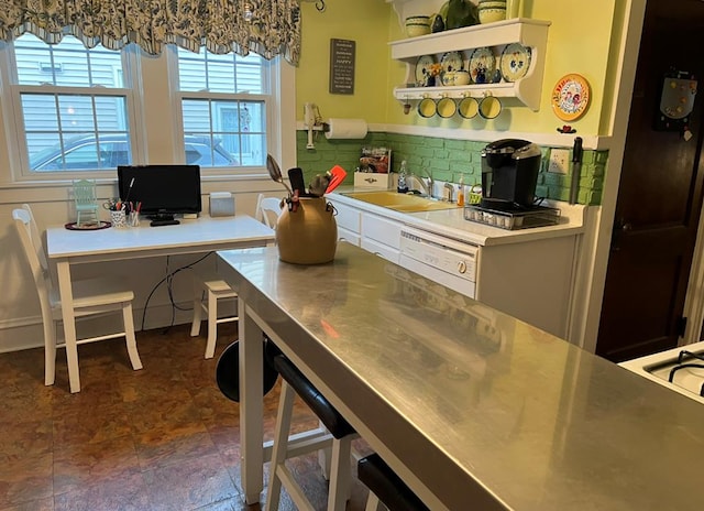 kitchen featuring sink, decorative backsplash, dishwasher, and stainless steel counters