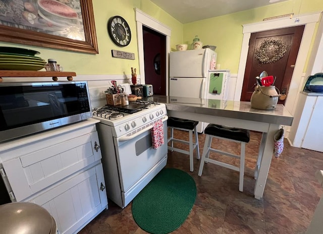 kitchen with white appliances and a breakfast bar