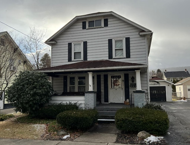 view of front of home featuring a garage, an outdoor structure, and covered porch