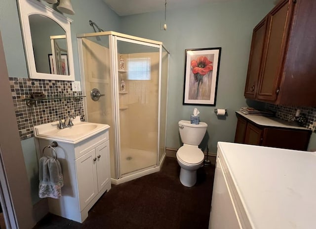 bathroom featuring walk in shower, vanity, toilet, and backsplash