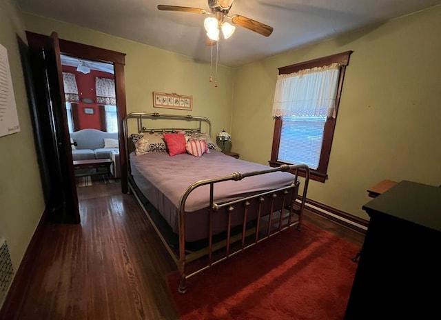 bedroom with multiple windows, ceiling fan, dark hardwood / wood-style flooring, and a baseboard radiator