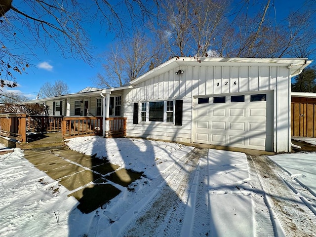 snow covered back of property with a garage