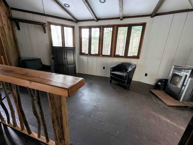 unfurnished living room featuring vaulted ceiling with beams, heating unit, and a wood stove