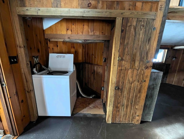 clothes washing area featuring wooden walls and washer / clothes dryer