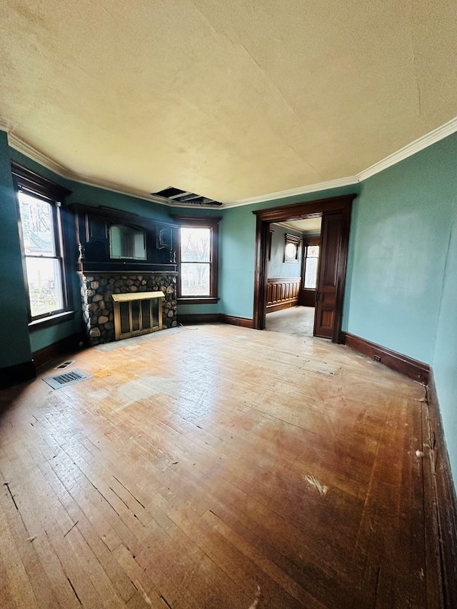 unfurnished living room with crown molding, wood-type flooring, a textured ceiling, and a fireplace