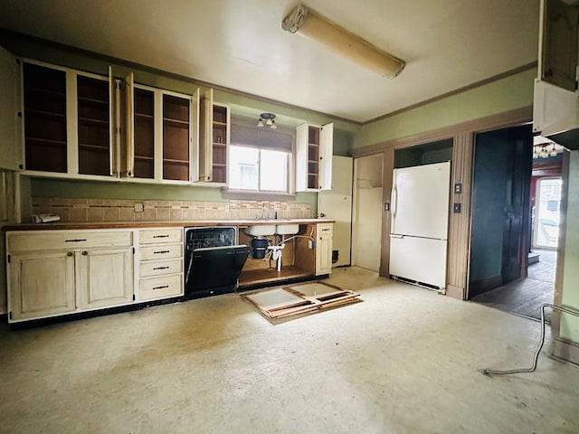 kitchen with a healthy amount of sunlight, concrete flooring, dishwasher, and white fridge