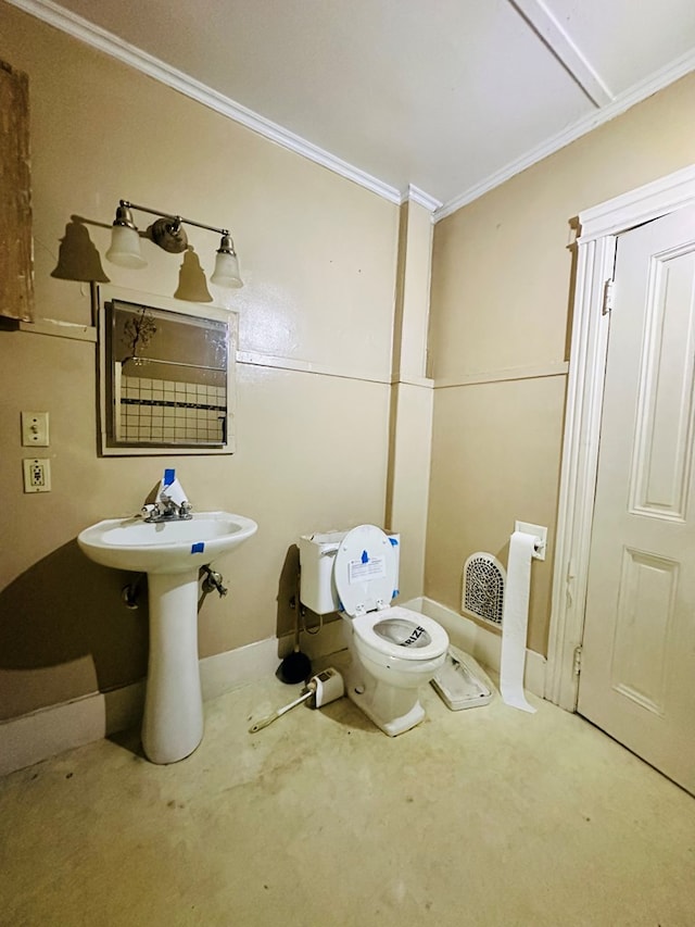 bathroom with ornamental molding, toilet, and sink