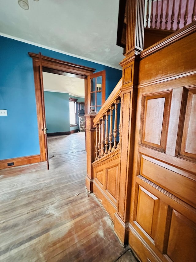 staircase with crown molding and wood-type flooring