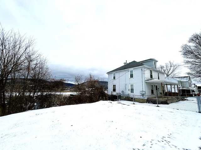 view of snowy exterior featuring covered porch