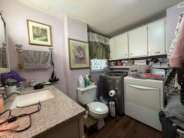 bathroom featuring hardwood / wood-style floors, vanity, washing machine and clothes dryer, toilet, and a textured ceiling