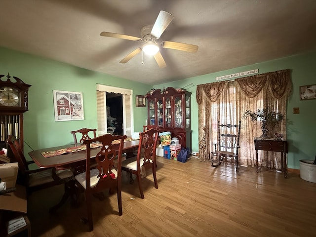 dining space with ceiling fan and wood-type flooring