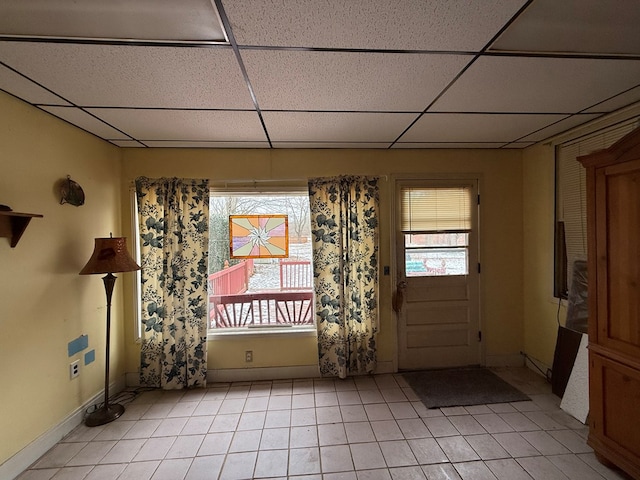 interior space with plenty of natural light, light tile patterned floors, and a drop ceiling