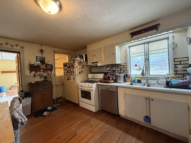 kitchen featuring wood-type flooring, sink, white appliances, and decorative backsplash