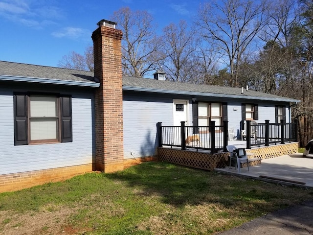 rear view of property featuring a patio, a deck, and a yard