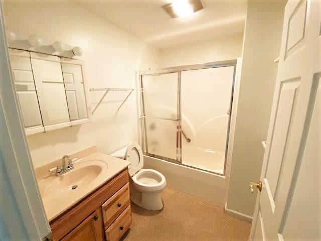 full bathroom featuring enclosed tub / shower combo, toilet, and vanity