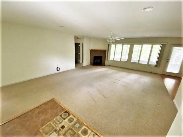 unfurnished living room featuring ceiling fan and light colored carpet