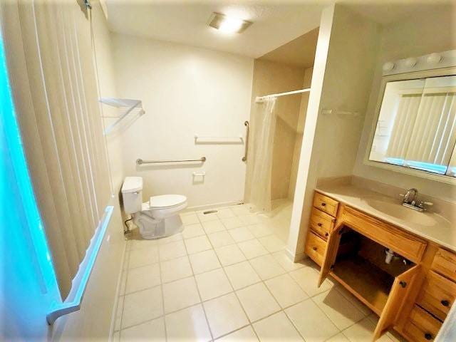 bathroom with tile floors, toilet, and vanity