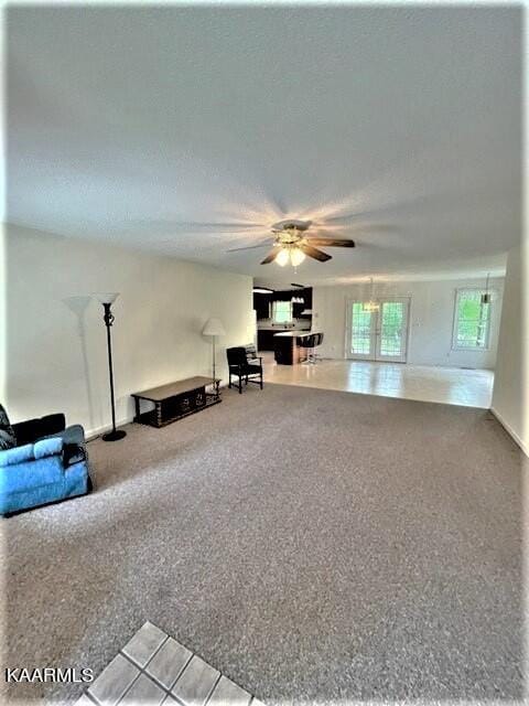 unfurnished living room with ceiling fan and carpet