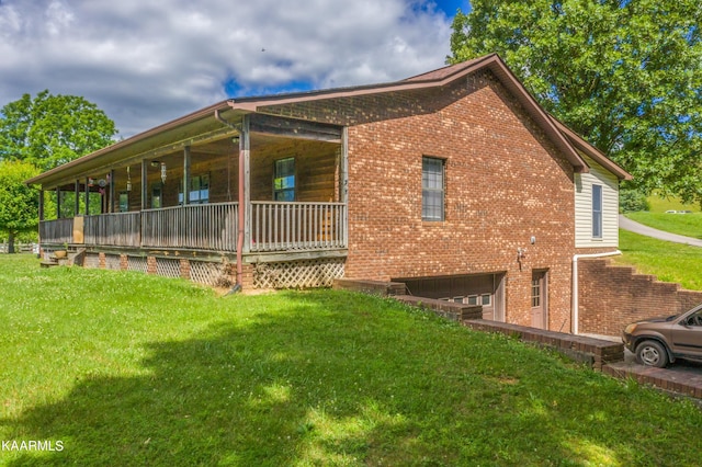 view of side of home with a yard, covered porch, and a garage