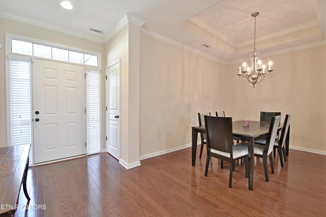 dining area with a tray ceiling, baseboards, a chandelier, dark wood finished floors, and visible vents