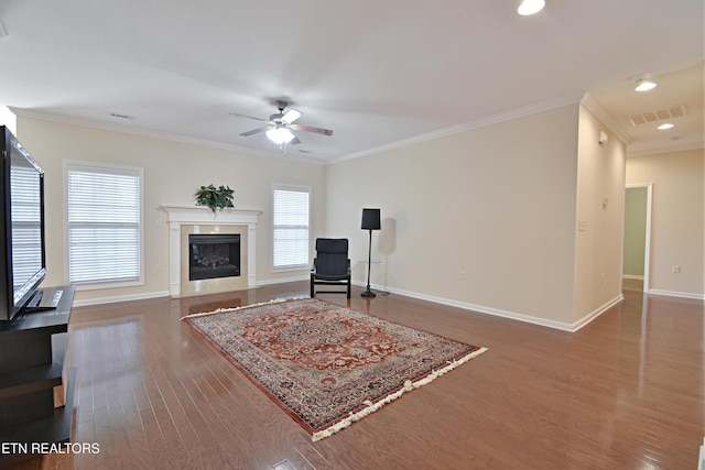 sitting room featuring wood finished floors, ornamental molding, ceiling fan, and visible vents