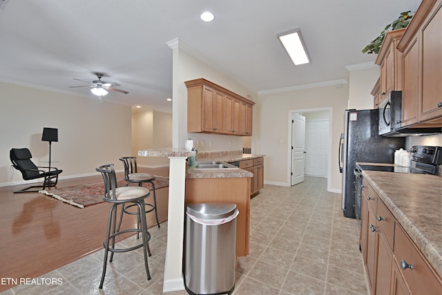 kitchen featuring a kitchen bar, crown molding, stainless steel microwave, ceiling fan, and a peninsula