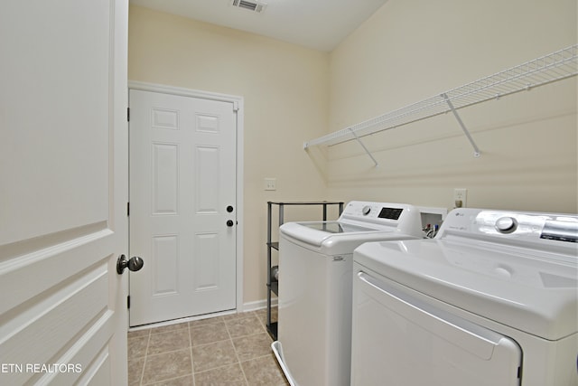 laundry room with washing machine and dryer, visible vents, laundry area, and light tile patterned floors