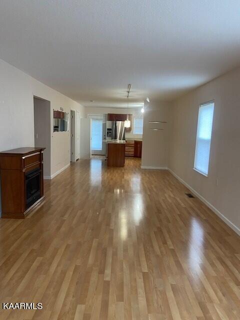 unfurnished living room with a healthy amount of sunlight and light hardwood / wood-style flooring