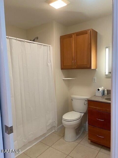 bathroom featuring toilet, tile flooring, and vanity