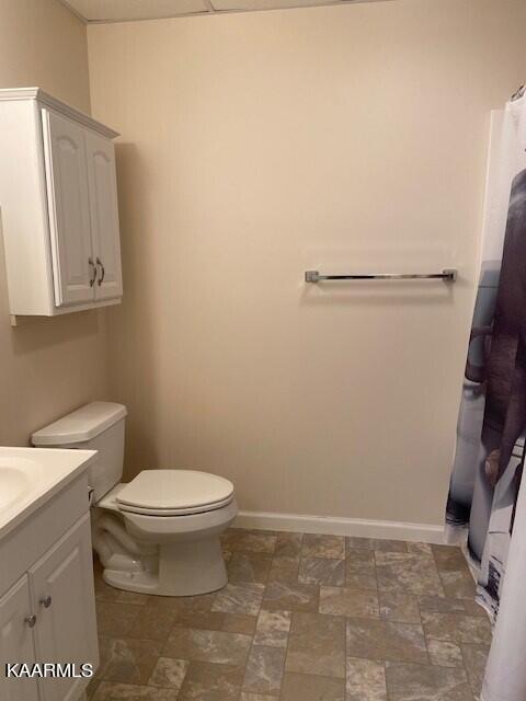 bathroom featuring toilet, vanity, and tile flooring