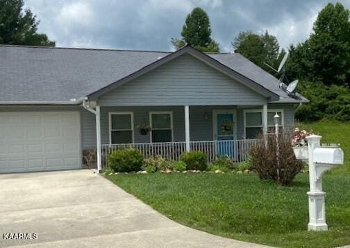 view of front of property featuring a front lawn, a porch, and a garage