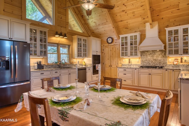 kitchen featuring high vaulted ceiling, appliances with stainless steel finishes, beamed ceiling, custom range hood, and wood ceiling