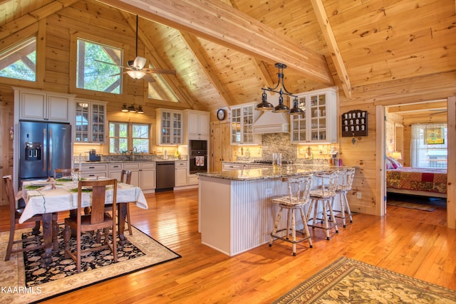 kitchen with appliances with stainless steel finishes, wood ceiling, pendant lighting, high vaulted ceiling, and beamed ceiling