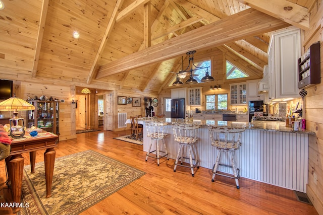 kitchen featuring beam ceiling, wooden ceiling, kitchen peninsula, and appliances with stainless steel finishes