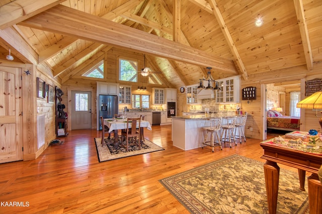 dining space with ceiling fan, beamed ceiling, high vaulted ceiling, light hardwood / wood-style floors, and wood ceiling