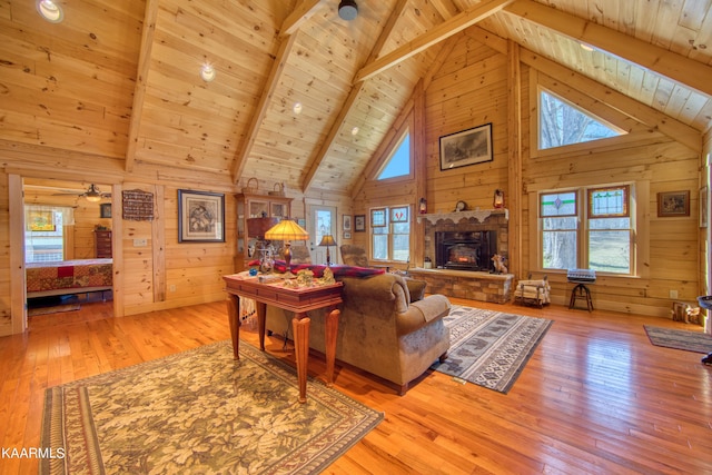 living room featuring beamed ceiling, wood ceiling, wooden walls, and light hardwood / wood-style flooring