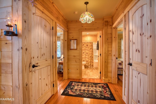 interior space with light hardwood / wood-style floors and wooden walls