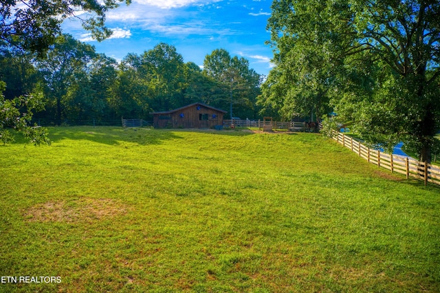 view of yard with a rural view and an outdoor structure