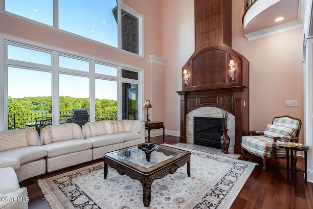 living room with a towering ceiling, dark hardwood / wood-style floors, and crown molding