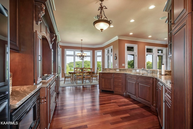 kitchen with decorative light fixtures, dark wood-type flooring, black microwave, light stone countertops, and ornamental molding